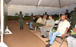 President David Granger (seated fourth from left) pays keen attention as Deputy Chief-of-Staff of the Guyana Defence Force Colonel George Lewis explains the elements of exercise ‘Homeguard.’ Minister of Foreign Affairs Carl Greenidge (seated at right), Prime Minister Moses Nagamootoo (seated second from right) and Minister of State Joseph Harmon (seated third from left) also look on. (Ministry of the Presidency photo)