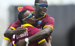 Carlos Brathwaite embraces Dwayne Bravo as they celebrate another Indian wicket during the opening Twenty20 International of the two-match series on Saturday. (Photo courtesy WICB Media)
