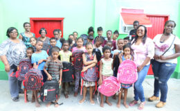 A group of children from Joshua House who received donations of backpacks and stationery from the Guyana Goldfields’ Women in Mining Group. In photo are: Gladys Accra, Administrator of the Joshua House Orphanage (left), Maya Layne (second, left), Trudy Ferrier (third, left), Nichola Scott (right) and Marisa Hohenkirk (second, right) of the Women in Mining Group.

