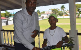 Best under-15 player Daniel Mootoo receives a pair of pair of gloves from Club President Alfred Mentore.
