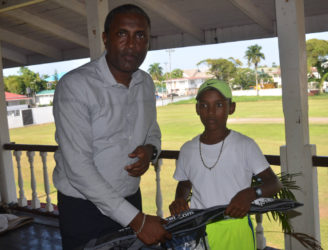 Best under-15 player Daniel Mootoo receives a pair of pair of gloves from Club President Alfred Mentore. 