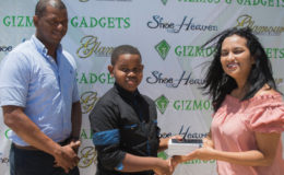 Pre-Cadet Caribbean U11 champion Kaysan Ninvalle (centre) receives the Samsung S7 Galaxy Edge phone from Gizmos and Gadgets Manager Sophia Dolphin while GTTA President Godfrey Munroe looks on.