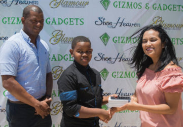 Pre-Cadet Caribbean U11 champion Kaysan Ninvalle (centre) receives the Samsung S7 Galaxy Edge phone from Gizmos and Gadgets Manager Sophia Dolphin while GTTA President Godfrey Munroe looks on.