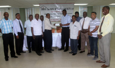 NBS CEO Mr. Anil Kishun hands over the sponsorship cheque to GCA President Roger Harper.