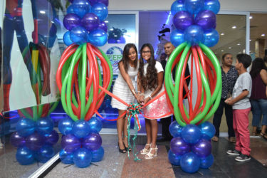 Co-Owner Jade Beepat (left) and her daughter (right) did the ceremonial ribbon cutting at the launch of the Universal Games Guyana Arcade on Tuesday evening.  