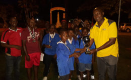 Plaisance captain and tourney MVP Azandee King collecting the championship trophy from Banks DIH Limited Malts Brand Manager Clayton McKenzie while other members of the team and the tourney coordinators look on. 