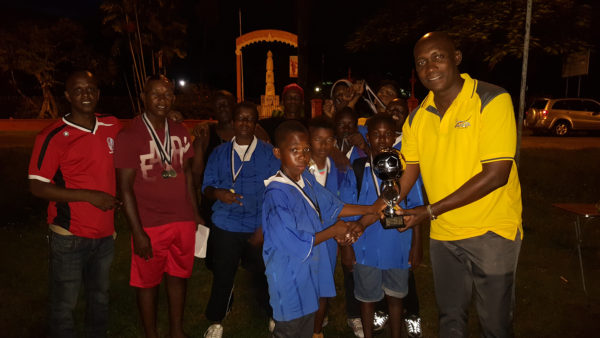 Plaisance captain and tourney MVP Azandee King collecting the championship trophy from Banks DIH Limited Malts Brand Manager Clayton McKenzie while other members of the team and the tourney coordinators look on. 