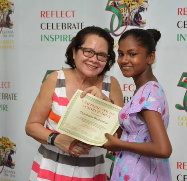 First Lady Sandra Granger yesterday attended the Science, Technology, Engineering and Mathematics (STEM) Guyana Graduation Ceremony at the National Sports Resource Centre on Woolford Avenue and said she was encouraged by the interest that the Lego Robotics Building and Programming Workshop has generated in young people. In this Ministry of the Presidency photo, the First Lady presents a Certificate of Achievement to Chandroutie Gooberdhan, one of the graduates from the workshop held at the Lusignan-good Hope Learning Centre, Lusignan, East Coast Demerara. 