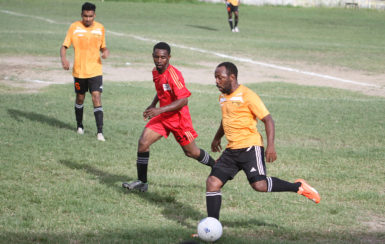 Veteran midfielder Troy Prescod (right) of Camptown in the process of initiating a pass while being pursued by GPF’s Kishawn Lovell during their matchup at the GFC ground in Mayor’s Cup Football Championship.  (Orlando Charles photo) 