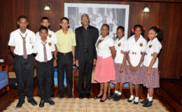 President David Granger is flanked by Carol Monroe (right) and  Bruce Monroe and students of the Phoenix Elementary School, during their visit to the Ministry of the Presidency earlier today. (Ministry of the Presidency photo)