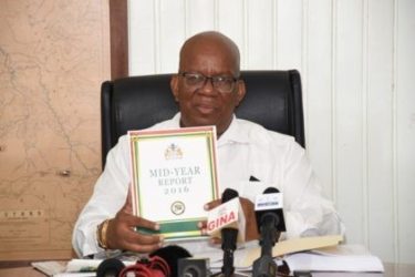 Minister of Finance, Winston Jordan displaying a copy of the Half- Year report (GINA photo)