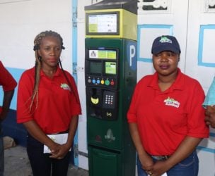 Two attendants with one of the parking meters