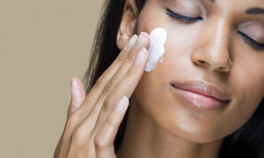 A woman rubbing moisturizer into her skin