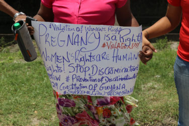 Rights activist Nicole Cole holds up a placard during the protest 