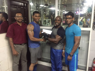 Senior trainer at Buddy’s Gym, Mervyn ‘Spongy’ Moses recently presents a cheque to Dmitry Chan ahead of the Raw National Championships on September 18 at the Critchlow Labour College.