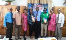 Winston George (third from right) and Alita Moore (fifth from right) pose with the top brass of NAMILCO following the presentation on Tuesday.