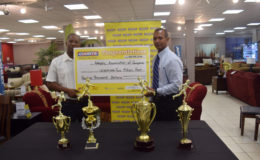 President of the AAG, Aubrey Hutson (right) receiving the sponsorship cheque yesterday from Courts (Unicomer Guyana Inc.) Marketing Managing Manager, Pernell Cummings. 