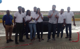 Manager of Yokohama Trading Guyana Deepak Balraj (centre) flanked by employees of the auto dealership during yesterday’s opening.  