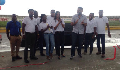 Manager of Yokohama Trading Guyana Deepak Balraj (centre) flanked by employees of the auto dealership during yesterday’s opening.  