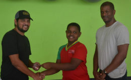 Proprietor of Fitness 53 and former West Indies batting ace Ramnaresh Sarwan (left) handing over the lifetime membership card to Kaysan Ninvalle (centre) while GTTA President Godfrey Munroe looks on
