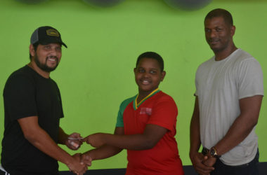 Proprietor of Fitness 53 and former West Indies batting ace Ramnaresh Sarwan (left) handing over the lifetime membership card to Kaysan Ninvalle (centre) while GTTA President Godfrey Munroe looks on 