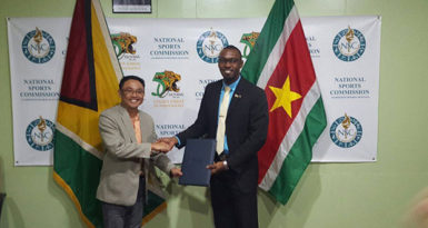 FLASHBACK! (L-R) Suriname Director of Sport, Luciano Mentowikromo and Guyana’s Christopher Jones display the Inter-Guiana Games agreement. 