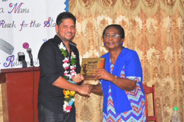 Ramnaresh Sarwan receives the plaque from his former Headmistress at Stella Maris `Primary School, Mrs Natalie Author.