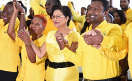 Opposition Leader Kamla Persad-Bissessar (second from right) holds hands with UNC Local Government candidates on Saturday at Couva South multipurpose hall during a song at the candidates’ presentation.
