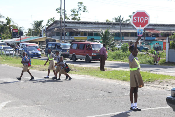 Road safety: St Pius Primary School’s Road Safety Patrol pupils helping peers cross the street after school yesterday afternoon. (Photo by Keno George) 