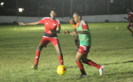 GDF’s Odesa Romeo (right) trying to keep possession of the ball while being pursued by Tiandi Smith of Foxy Ladies during their matchup at the Camp Ayanganna ground
