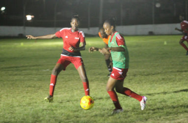 GDF’s Odesa Romeo (right) trying to keep possession of the ball while being pursued by Tiandi Smith of Foxy Ladies during their matchup at the Camp Ayanganna ground 