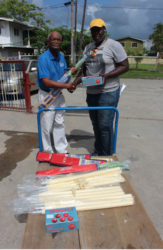 Joel Alleyne, right, of the Malteenoes Cricket Club receives the equipment from Food for the Poor’s Wayne Hamilton. 