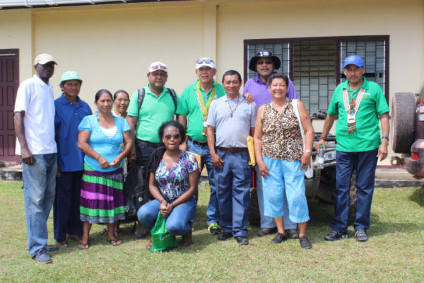 Minister of Indigenous Peoples’ Affairs Sydney Allicock (at right), Ministerial Advisor Mervyn Williams (at right in background) and Minister of Public Health Dr. George Norton (at centre in background) in the company of residents and health care professionals during their recent visit to Aishalton. 