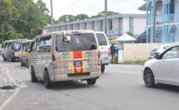A police officer escorting this line of buses and taxis to the Brickdam Police Station this morning after receiving reports that the drivers had been committing various traffic offences. 