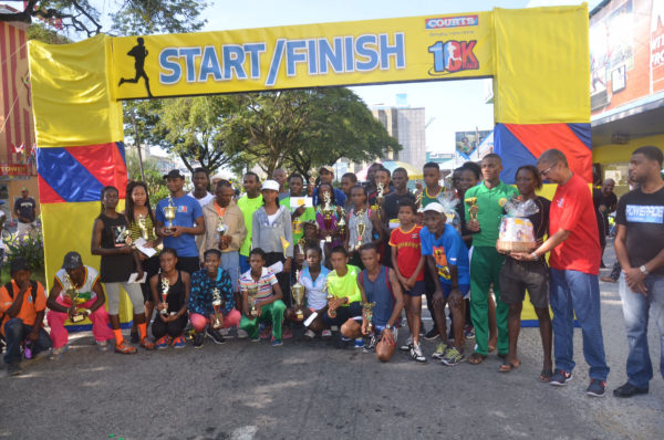 The top prize takers pose for a photo in front of Courts on Main Street following the sixth annual 10K and Fitness Run.