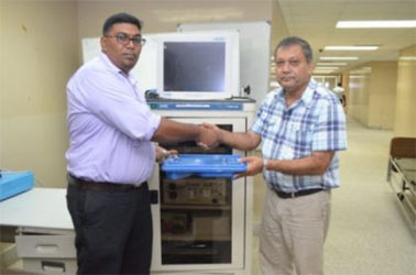 Surgeon and Senior Surgical Registrar, Dr. Ravi Motilall (left) hands over endoscopic equipment to Chief Executive Officer of the Georgetown Public Hospital Corporation, Michael Khan (GINA photo)