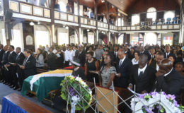 Justice Winston Moore’s widow, Vera Moore, glances over at the casket bearing her late husband’s remains during his funeral service at St Andrew’s Kirk yesterday. Standing next to her are three of her children. Also in picture (from second left) are Attorney-General Basil Williams, Speaker of the National Assembly Dr. Scotland Barton and acting President Moses Nagamootoo. (Keno George photo).
