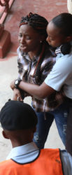 A police officer attempts to escort Rushelle Gittens out of the court compound