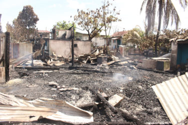 The charred remnants of Lot 50 McDoom, where the fire reportedly began before spreading to other homes. (Photo by Keno George)