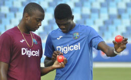 PACE TWIN: Rookie fast bowlers Miguel Cummins (left) and Alzarri Joseph examine the pink ball during practice ahead of today’s start of the opening Test in Dubai. (Photo courtesy WICB Media)