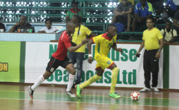 Nyk Nichols (28) of Guyana trying to launch an attack while being pursued by a Surinamese player during their matchup at the Cliff Anderson Sports Hall in the Inter-Guiana Games Futsal encounter yesterday. (Orlando Charles photo) 

