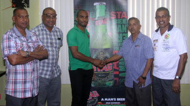 Lindon Henry of Stag Beer  shake hands with GFSCA President Ramchand Ragbeer at yesterday’s sponsorship ceremony. (Orlando Charles photo)