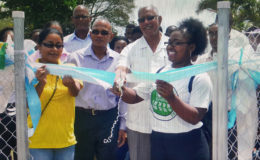Minister Noel Holder being assisted to cut the ribbon to commission the Hydromet Service’s Climatological Station at the Guyana School of Agriculture. (Shabna Rahman photo)
