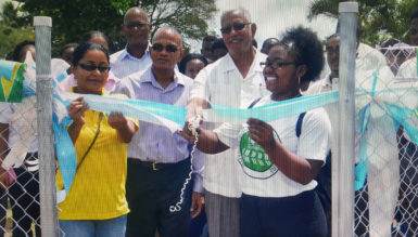 Minister Noel Holder being assisted to cut the ribbon to commission the Hydromet Service’s Climatological Station at the Guyana School of Agriculture. (Shabna Rahman photo)