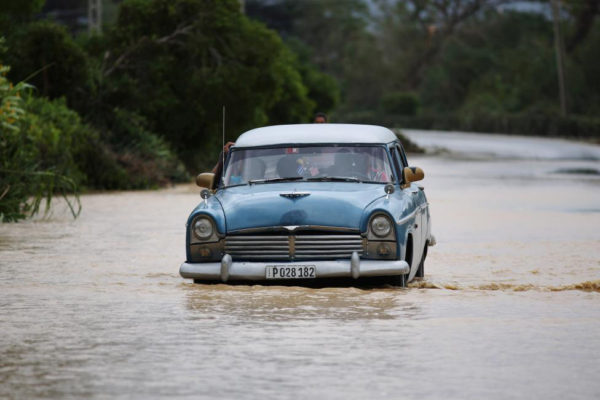 A vintage car crosses a flooded highway in Guantanamo Province, Cuba after Hurricane Matthew passed (Reuters/Alexandre Meneghini)  