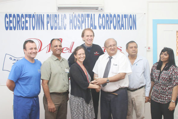 Chairman of the Georgetown Public Hospital Corporation Board Dr Carl Max Hanoman (third, right) presenting a token of appreciation to Dr Joanna Cole, Consultant, Internal Medicine (third, left). Dr Cole, whose contract came to an end on October 1, was a full-time instructor in the Department of Medicine at the University of Maryland School of Medicine from July 2013 to August 2014 and was assigned to the GPHC to work along with residents in the Masters in Internal Medicine/Infectious Diseases programme. Also in photo from left are: Dr Rodrigo Soto and Dr Clint Doiron of the Baby Heart Organization,  Dr Sheik Amir, GPHC CEO Michael Khan and Dr Merissa Seepersaud. The presentation was done on Friday.