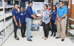 General Manager of Toolsie Persaud Ltd Ray Sukhnandan hands over a cheque to Deborah Ramotar-Skeete, the Administrative Coordinator of the Guyana Book Foundation to aid in its literacy programmes. (Photo by Keno George)