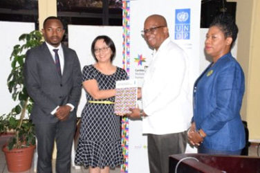 Minister of Finance Winston Jordan (second from right) receives the CHD Report from UN Resident Coordinator Mikiko Tanaka while UNDP Regional Advisor Kenroy Roach and Deputy Vice Chancellor of the UG Dr Barbara Reynolds look on (GINA photo)