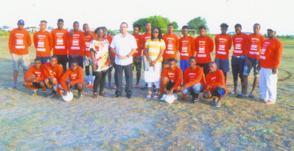 UK based Guyanese Anthony Price (centre) posing with members of the Trafalgar United FC, inclusive of Club Coordinator Yvette Price, after a simple presentation of football kits and equipment at the No. #30 Ground in West Coast of Berbice. The presentation was done on behalf of Pastey Farr of Sainsbury’s Supermarket in Winchester, England. 