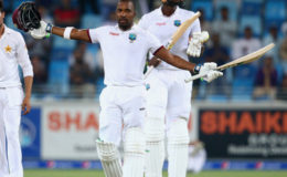Batsman Darren Bravo celebrates his eighth Test hundred yesterday as captain Jason Holder (right) applauds the occasion. (Photo courtesy WICB Media) See page 26